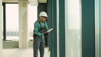Construction worker inspecting walls in unfinished building video