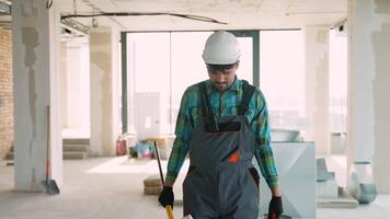 Construction worker walking towards camera in unfinished building video