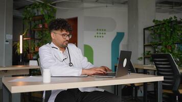 Doctor working on laptop and taking notes in modern clinic video