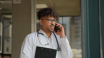 Doctor making a phone call while holding a clipboard video
