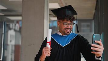 Happy graduate making a call showing his diploma video