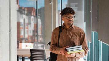 Confident student carrying books in university hallway video
