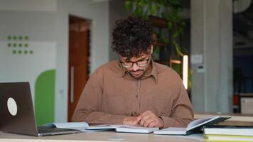 Focused student reading and taking notes in modern library video