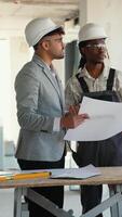 Architects discussing blueprint on construction site video