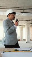 Architect communicating on walkie talkie during building inspection video