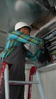 Electrician working on electrical panel installing cables video