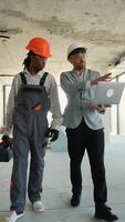 Construction worker and architect discussing building plans on laptop video