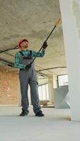 Construction worker applying primer on walls in building video