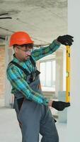 Construction worker checking vertical alignment with spirit level video