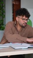 Focused student taking notes while studying in modern library video