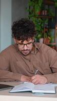 Focused employee taking notes and typing on laptop in modern office video