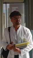 Medical student intern walking through corridor holding books video