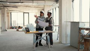 Architect and engineer discussing building plans in unfinished building video