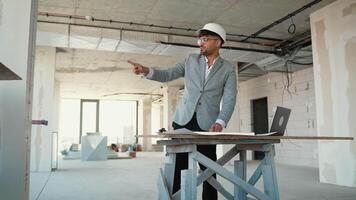 Architect evaluating blueprints and pointing in building under construction video