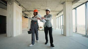 Architect and construction worker discussing building plans video