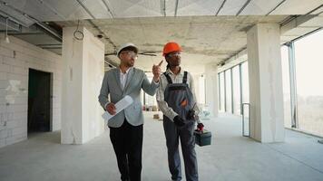 Architect and construction worker discussing building plans video