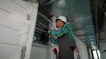 Electrician installing cables and components in electrical panel video