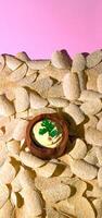 Potato Chips and Creamy Dip on Pink Background photo