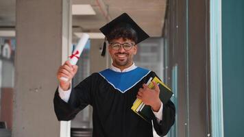 Happy graduate holding diploma and books smiling at university video