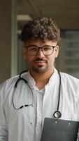 Young doctor smiling and holding a clipboard, six different expressions video