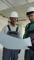 Construction workers examining blueprint on site video