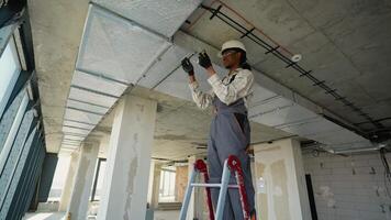 Electrician installing electrical wiring on ceiling video