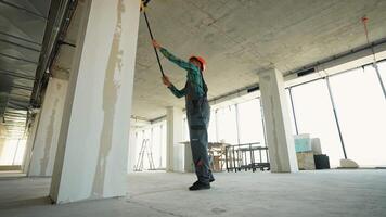 Professional painter applying primer on walls in new building video
