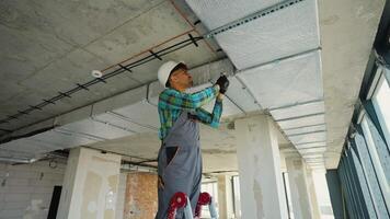 Construction worker installing air duct insulation in building video