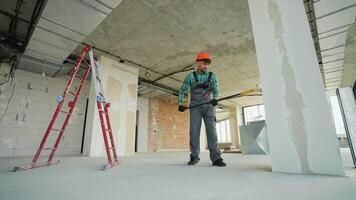 Construction worker priming walls in unfinished building video