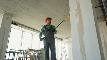 Construction worker priming walls in a building under construction video