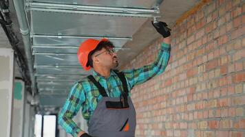 Electrician installing light in ceiling grid video