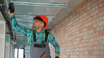 Electrician installing suspended ceiling in building under construction video