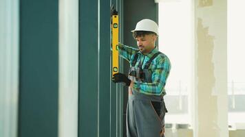 Construction worker checking vertical alignment with spirit level video