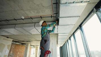 Electrician installing cables on a ceiling video