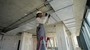 Electrician installing cable tray and wiring in building under construction video