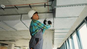 Professional electrician installing electrical cables in building ceiling video