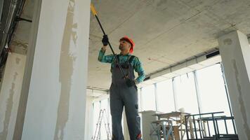 Painter priming walls in a building under construction video