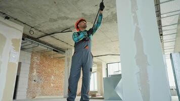 Construction worker priming walls in building renovation video