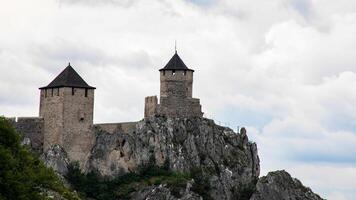 Ancient stone fortress crowns jagged cliffs under tumultuous skies, evoking medieval intrigue, fortress festivals, and historys hidden tales photo