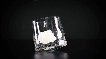 Ice cube tumbles into a glass video