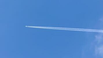 A solitary jet pierces the azure sky with whispering contrail secrets, echoing World Aviation Day and Sky Awareness Week photo