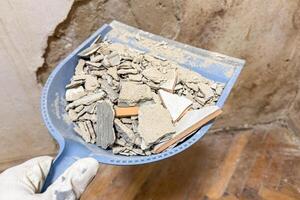 Dustpan cradles shattered dreams of renovation with a mosaic of plaster and timeworn tiles fitting for World Habitat Day photo