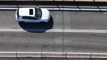 Overhead view of cars moving across a bridge under bright sunlight, highlighting urban transportation dynamics video