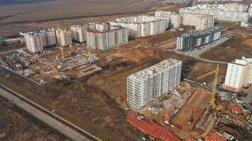 Construction activity in a growing town featuring multiple residential buildings and cranes photo