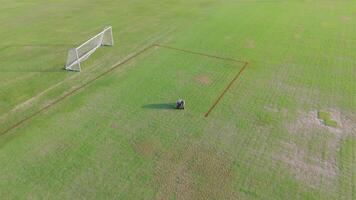 Aerial view of a robot autonomously painting precise lines on a soccer field under clear daylight video