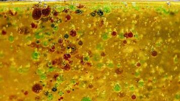 Vibrant chemical reaction with colorful droplets in a beaker, showcasing density and separation over 16 seconds video