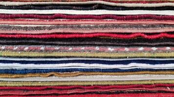 Closeup of folded rugs texture. Striped pattern background photo