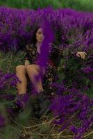 Brunette woman relaxing in a field surrounded by vibrant delphiniums during a sunny day in a beautiful natural setting photo