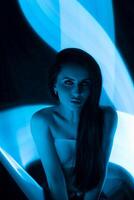 Captivating portrait of a woman in blue light showcasing creative lighting techniques and artistic expression photo
