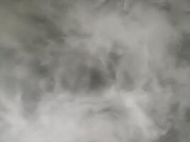 Grey smoke and white fog form an abstract background texture. dark atmosphere feels ethereal with swirling pattern of mysterious steam and misty vapor effect photo